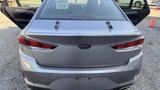 A 2018 Hyundai Sonata with a silver exterior and distinct rear taillights is parked, showcasing its sleek design and modern styling