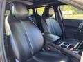 Interior view of a 2023 Fisker Ocean showing two black leather front seats with a central console and storage area between them