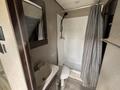 Interior view of a bathroom featuring a shower with a curtain a sink with a countertop and a toilet