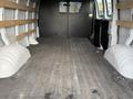 Interior of a 2023 GMC Savana cargo van featuring a spacious, empty cargo area with reinforced flooring and wooden support beams along the walls