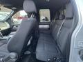 Interior view of a 2014 Ford F-150 showing the rear seating area with dark fabric seats and a spacious cabin layout
