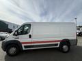 A 2017 RAM Promaster van with a white exterior and a red stripe along the side parked in a lot