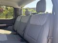 The interior of a 2023 Ford F-350 SD showing the back seat with gray fabric upholstery and seat belts
