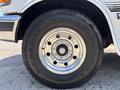 The close-up of a chrome wheel of a 1995 Ford F-250 featuring a black tire with the text GT Radial Adventuro written on it