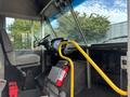 Interior view of a 2018 Ford Econoline showing the driver's seat steering wheel and a yellow handrail with a fire extinguisher nearby