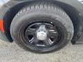 Close-up of a black wheel with a silver center cap on a 2015 Dodge Charger featuring a Firehawk tire