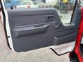 A gray interior door panel of a 2001 Toyota Dyna with a handle and a window crank