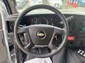 The interior of a 2020 Chevrolet Express showing a steering wheel dashboard and control panel with gauges and audio controls