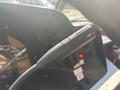 A close-up view of a turn signal lever from a 2012 Ford E-450 dashboard featuring a black handle with a directional arrow design