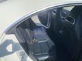 Interior view of a 2014 Mercedes-Benz CLA-Class showcasing black leather rear seats and door panel details