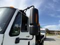A 2011 International 4300 truck with a prominent side mirror and a reflective orange light attached to the mirror arm