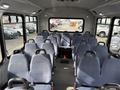 Interior of a 2018 Chevrolet Express with multiple rows of blue fabric-covered seats and a spacious aisle in between