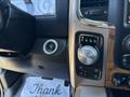 The interior dashboard of a 2015 RAM 1500 featuring gear shift dial with settings for park reverse neutral drive and a push to start button