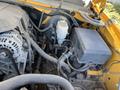 A close-up view of the engine compartment of a 2013 Chevrolet Silverado 1500 showing various components including cables an alternator and a battery