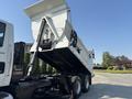 A 2013 International WorkStar truck with an elevated dump bed showcasing its hydraulic mechanism and trailer chassis