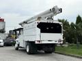 A white 2006 International 4300 bucket truck with an extended boom and a rear storage compartment