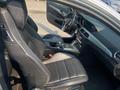 Interior view of a 2013 Mercedes-Benz C-Class showing black leather seats and a modern dashboard with controls and a gear shift