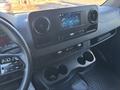 Interior dashboard of a 2024 Mercedes-Benz Sprinter 2500 featuring a touchscreen display and control buttons with cup holders below