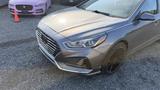 A gray 2018 Hyundai Sonata with a sleek front design and distinctive grille showcasing a modern look and sporty features
