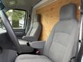 A 2022 Ford E-450 vehicle interior featuring two grey fabric seats with armrests and a wooden wall panel behind the seats