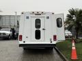 A white 2017 Ford E450 with a raised rear door and handicap access symbols