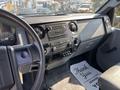 Dashboard of a 2018 Ford F-750 featuring controls for audio and climate settings along with a floor mat that says Thank You Its Been A Pleasure Serving You