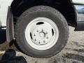 A close-up of a white wheel and tire mounted on a 2016 Ford Econoline showing a rugged tire tread pattern and five lug nuts