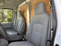 Interior of a 2023 Ford E-450 showing two gray upholstered seats without coverings and a simple dashboard design