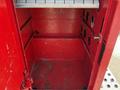 A red storage compartment with a metal shelf and multiple circular cutouts for ventilation or access