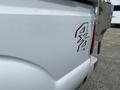 Close-up of the rear of a white 2014 Ford F-350 SD showing the 4x4 emblem attached to the side of the truck