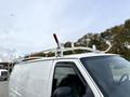 A 2008 Ford Econoline van with a white exterior and a roof rack featuring red and white handles.