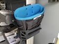 A blue and black tool organizer attached to a storage unit with various pockets and slots for holding tools and equipment