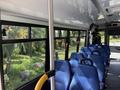 Interior view of a 2020 Chevrolet Express showing blue upholstered seats and a metal pole in the foreground
