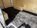 A 2022 Mercedes-Benz Sprinter interior featuring wooden flooring and two wooden crates positioned against the walls