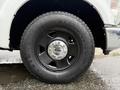 A black wheel with a silver Ford hubcap and a rugged tire tread of a 2008 Ford F-250 SD