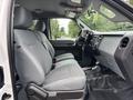 The interior of a 2013 Ford F-250 SD showing the front seats with gray fabric upholstery and a dashboard dashboard displaying controls and storage compartments