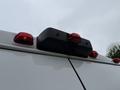 A rearview camera mounted on the back of a white 2020 RAM Promaster with red tail lights visible above it