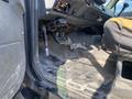 Interior view of a 1996 GMC Top Kick showing the driver side with a worn floor mat exposed pedals and various controls on the dashboard