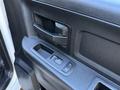 Interior door handle and window control panel of a 2021 RAM 5500 featuring a textured grip and buttons for locking and window operation
