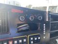 Dashboard controls of a 2011 Chevrolet Express featuring three temperature knobs a blank space for a radio and multiple buttons for various functions