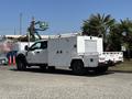 A 2017 Ford F-550 service truck with a white utility body featuring multiple compartments and lights on the back