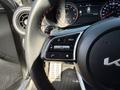 The interior of a 2024 Kia Forte5 showcasing the steering wheel with control buttons and a digital instrument cluster in the background