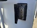 An electrical outlet with a protective cover mounted on a white surface of a 2005 Freightliner M2 106
