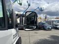 A 2023 RAM Promaster 3500 with a side mirror prominently displayed in the foreground