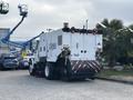 A 2012 International DuraStar 4300 street sweeper with a white body and multiple warning lights on the rear side