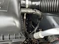 Close-up of the engine compartment of a 2015 RAM 2500 featuring various hoses and components with a focus on the air intake and engine cover
