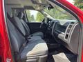 A red 2013 RAM 2500 pickup truck interior featuring gray cloth front seats with seatbelts and a dashboard with various controls and displays