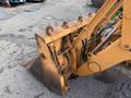 A 2005 Case 570 equipped with a front loader attachment showing visible wear and rust on the machinery and hydraulic components