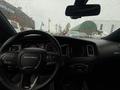 The interior of a 2017 Dodge Charger with a steering wheel featuring the Dodge logo and a digital dashboard displaying various gauges and controls