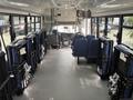 Interior of a 2020 Chevrolet Express with multiple seating options and safety restraints visible along the sides of the bus